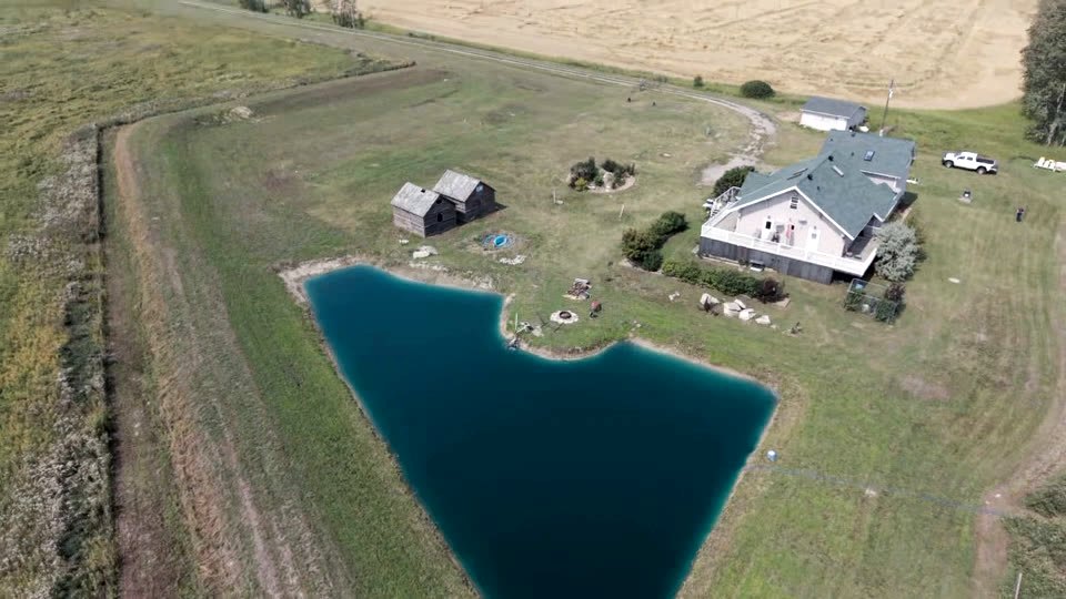 Aerial view of the pond, the shoreline fire pit and the log cabins
